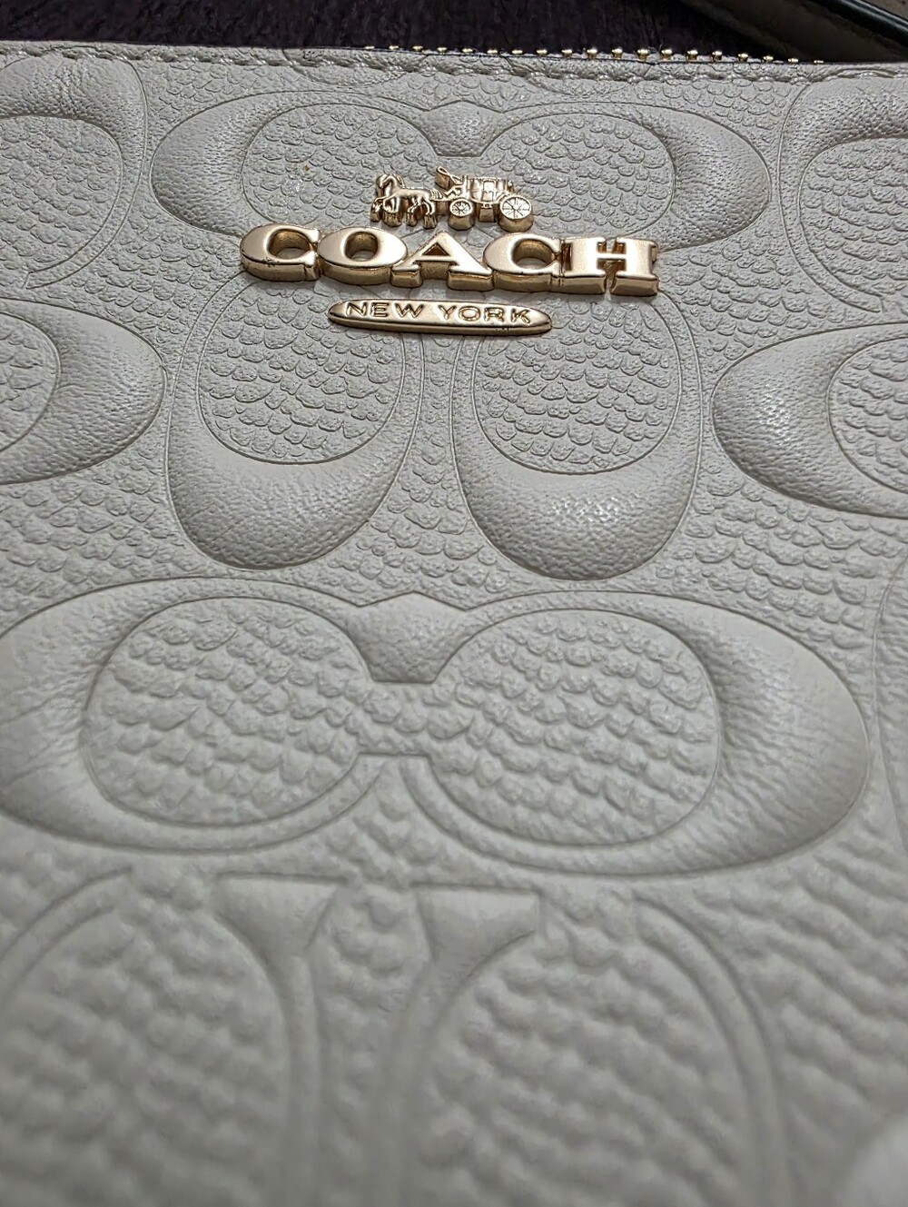 White embossed Coach Signature Leather Corner Zip Wristlet